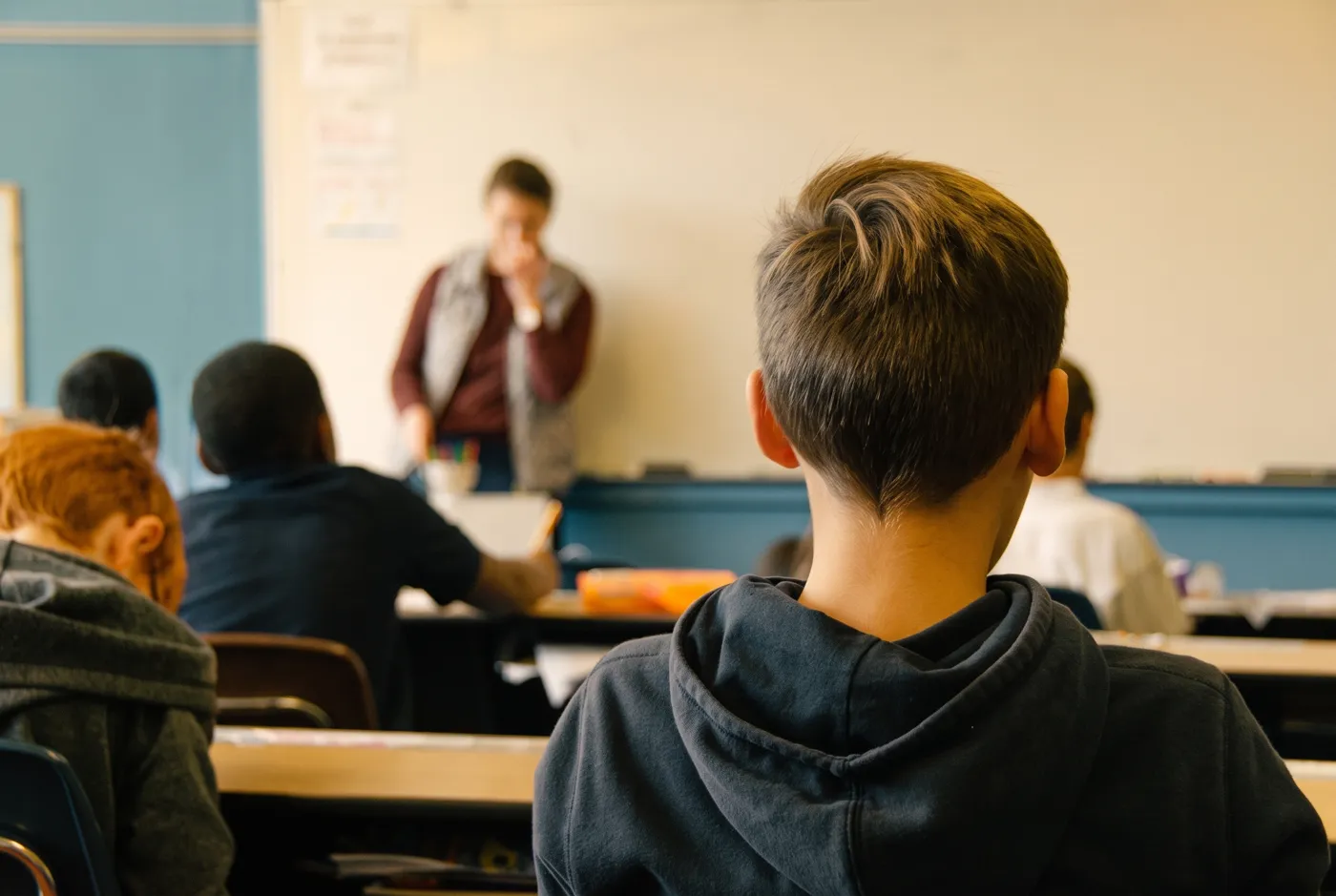 Alumnos en clase, con la docente en la pizarra