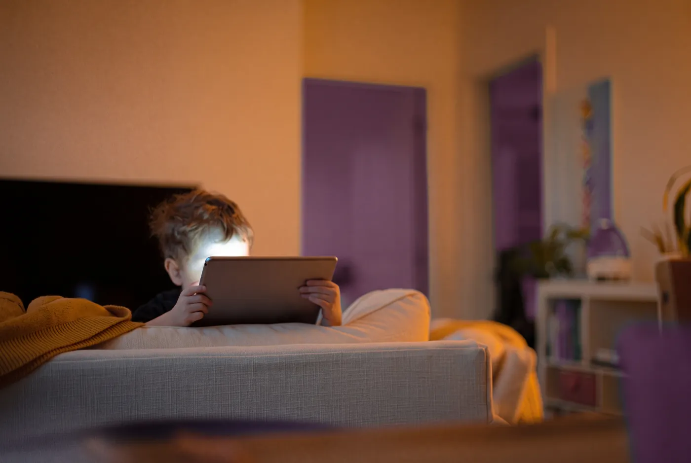 Un niño practica con la tableta en el sofá de casa